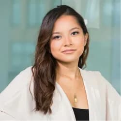 A woman with long hair wearing a white jacket.