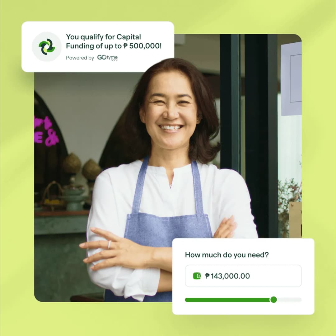 A woman with an apron is smiling for the camera.