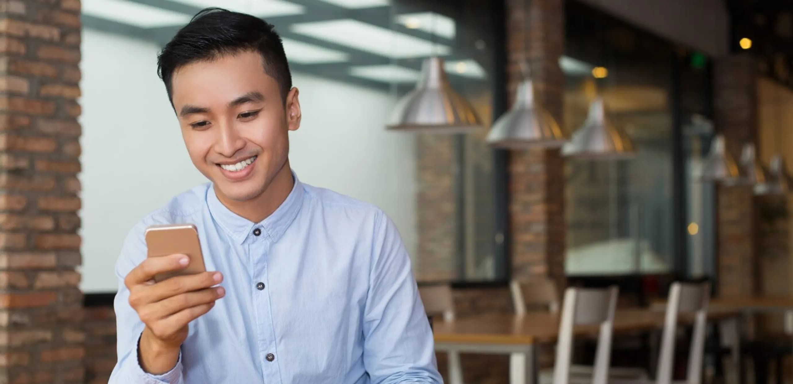 A man smiling while holding a cellphone